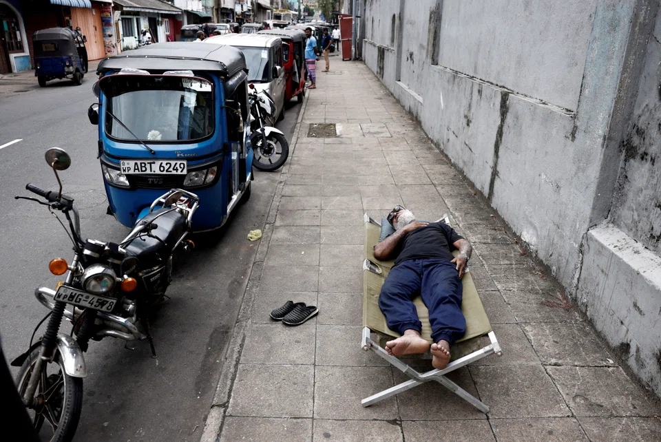 A man sleeps on a folding bed on a pavement as he waits in queue to buy petrol due to fuel shortage, amid the country's economic crisis, in Colombo, Sri Lanka. 