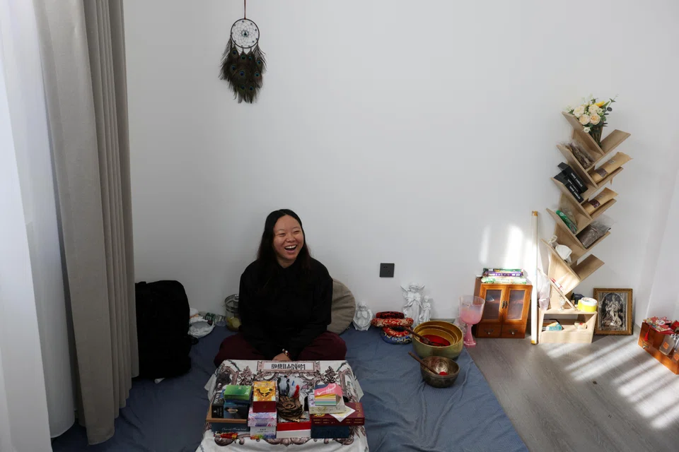 Bai Yunxi, 33, a full-time astrologer, laughs during an interview with Reuters in Dali, Yunnan province, China, Nov 10, 2023. 