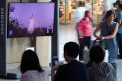 TV broadcasting North Korea's firing of a ballistic missile off its east coast at a railway station in Seoul. The suspected ICBM flew for 74 minutes to an altitude of 6,000 km and range of 1,000 km.