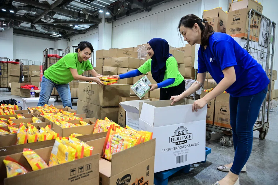 Volunteers from Standard Chartered Singapore at the event organised by Community Chest and Heartwarmers, which saw individuals and over 40 companies mobilised to donate, pack and distribute bags of blessings or fu dais. 