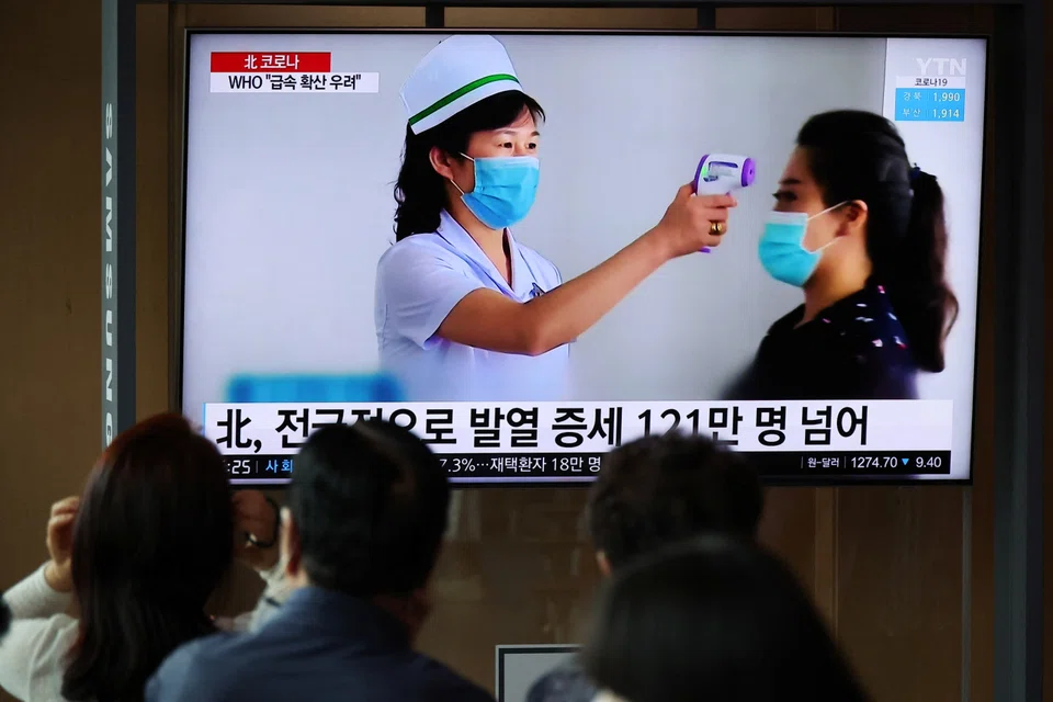 People watch a TV broadcasting a news report on the Covid-19 outbreak in North Korea, at a railway station in Seoul, South Korea, May 17, 2022.    