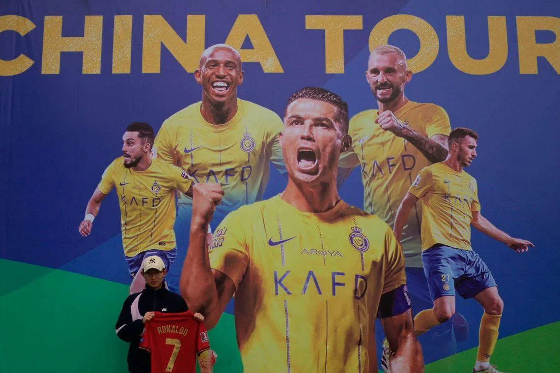 A Ronaldo fan posing for a picture prior to a training session in Shenzhen. Al Nassr Football Club has apologised for the cancellation of two matches due to the football superstar's injury.