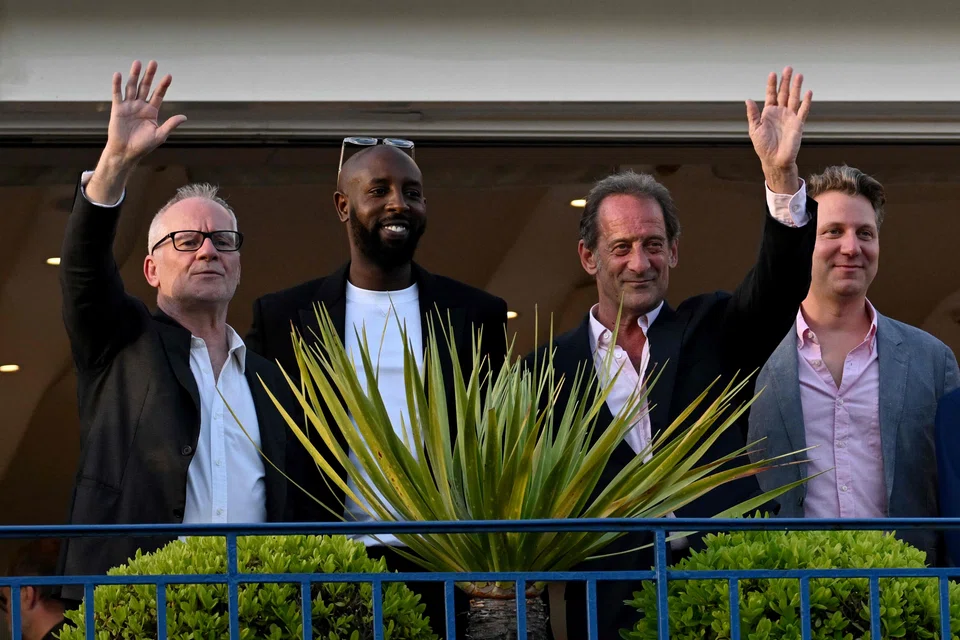 (FromL) Cannes Film Festival director Thierry Fremaux, French director and member of the Jury of the Official Selection Ladj Ly, French actor and President of the Jury of the 75th Cannes Film Festival Vincent Lindon and US film director Jeff Nichols wave from a balcony of the Grand Hyatt Cannes Hotel Martinez on the eve of the opening ceremony of the 75th edition of the Cannes Film Festival in Cannes, southern France, on May 16, 2022. 