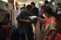 Indian health workers screen passengers arriving from high-risk countries for symptoms of the Monkeypox virus at Chennai International Airport, in Chennai, India, 16 July 2022. 