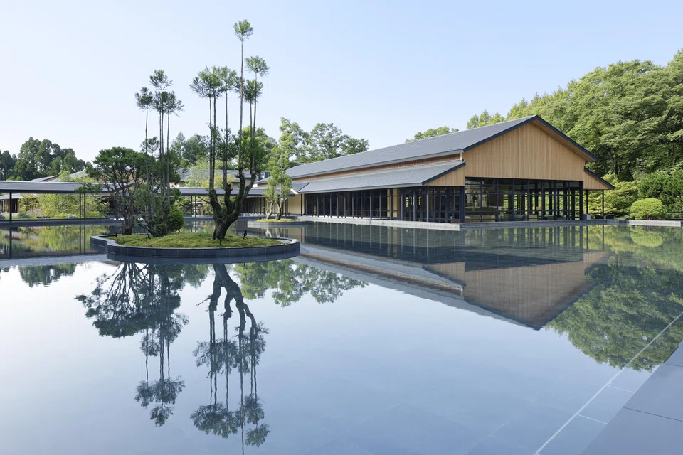 The beautiful surrounding nature reflected on the surface of Roku Kyoto's water basin.