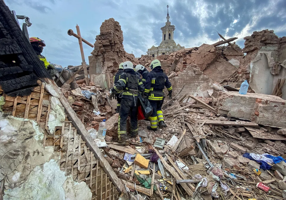Rescues carry a bag with the body of a 10-year-old boy at a site of a residential building damaged by a Russian missile strike in Kharkiv, Ukraine, Oct 6, 2023.     
