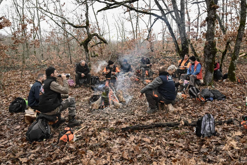 In a forest in northern Greece, lumberjacks rest around a fire on Dec 8. Their efforts help local populations to heat their homes at affordable prices.