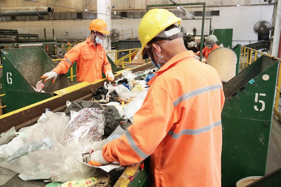 Workers sorting out waste at SembWaste, the waste-management unit of Sembcorp Industries.