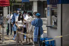 Residents queue at a Covid-19 testing booth in Shanghai, China, on Monday, June 20, 2022.  China on Tuesday slashed the quarantine time for inbound travellers by half in a major easing of one of the world’s strictest Covid-19 curbs.