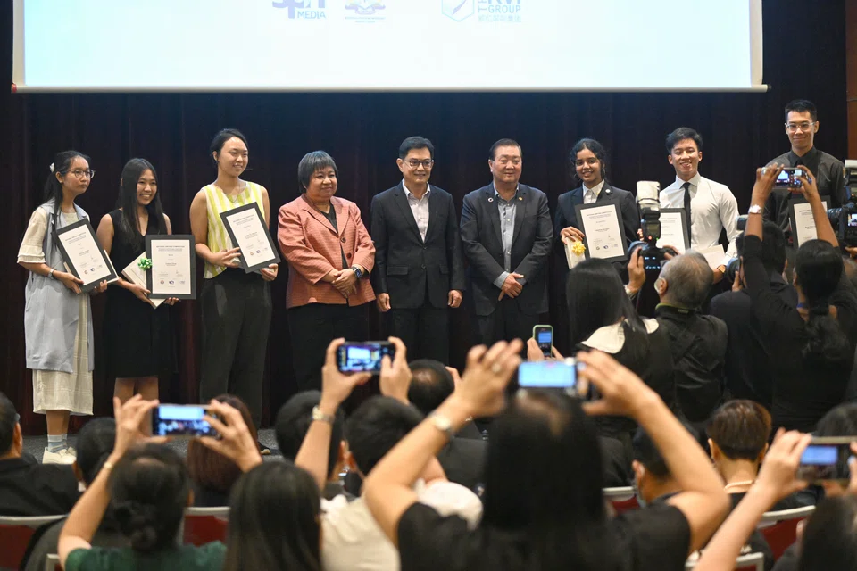 Deputy Prime Minister and Coordinating Minister for Economic Policies Heng Swee Keat (fifth from left) presents awards to the winners of the National Writing Competition.