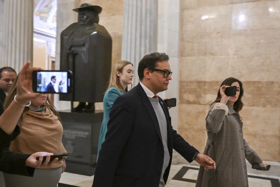 George Santos is surrounded by reporters as he walks through the US Capitol building in Washington on Jan 6, 2023. The new congressman is facing calls to resign by several Republican House colleagues. 