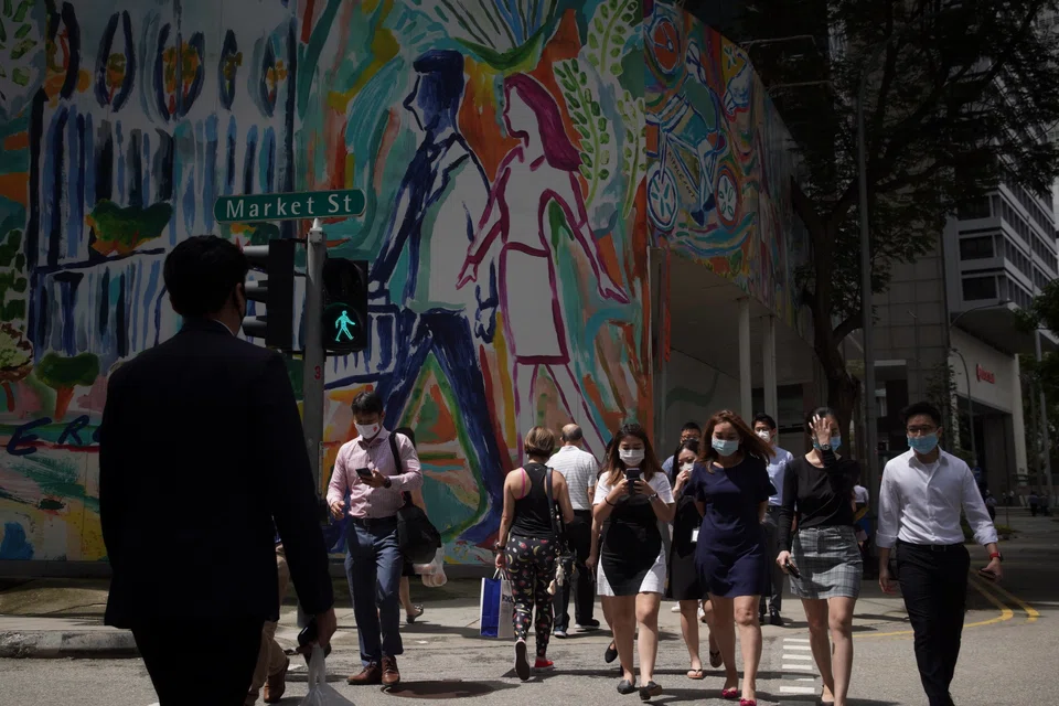 Office workers at a crossing in the Central Business District. High-calibre talent would have been able to enter Singapore under other passes, but the One Pass enables them to contribute as fully as possible.