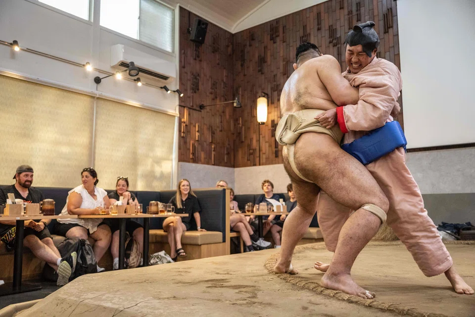 After a lunchtime “performance” in a Tokyo restaurant full of cheering tourists, spectators don padded sumo costumes to try their hand at the ancient art in a bout against retired professionals.