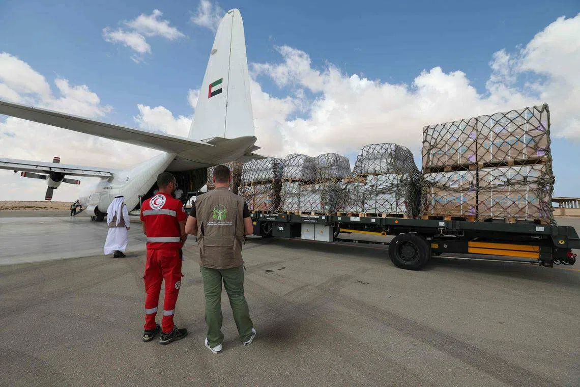 Staff members unload aid for the Palestinian Gaza Strip from an Emirates cargo plane on the tarmac of Egypt's el-Arish airport in the north Sinai Peninsula.  US President Joe Biden struck a deal with Egypt and Israel to allow relief in. 