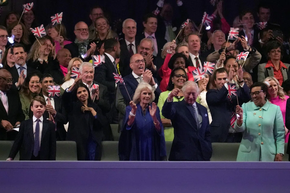 King Charles III and Queen Camilla wave from the royal box during a concert at Windsor Castle in Windsor, England, Sunday, May 7, 2023, celebrating the coronation of King Charles III. 