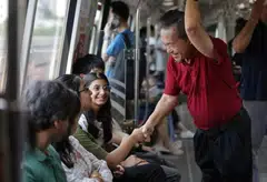 Presidential hopeful Tan Kin Lian greeting commuters on board an MRT train during his journey from Bedok station to Bukit Panjang station on Aug 17. ST PHOTO: GIN TAY