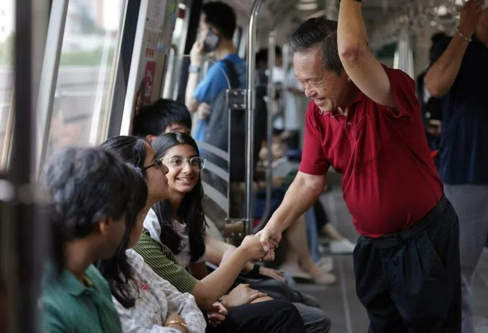 Presidential hopeful Tan Kin Lian greeting commuters on board an MRT train during his journey from Bedok station to Bukit Panjang station on Aug 17. ST PHOTO: GIN TAY