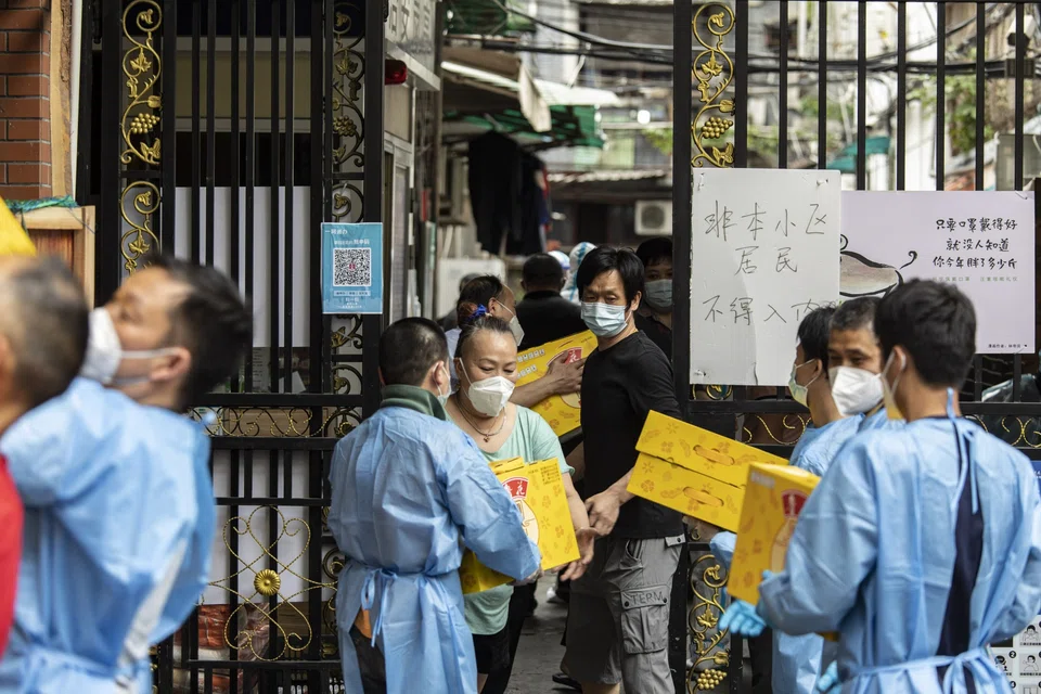 Workers deliver items of food to residents at a neighbourhood under lockdown in Shanghai, on May 7.