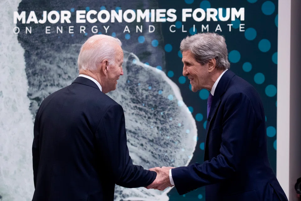 US President Joe Biden (L) and United States Special Presidential Envoy for Climate John Kerry (R) greet one another before the start of a virtual meeting with leaders of the Major Economies Forum on Energy and Climate (MEF).