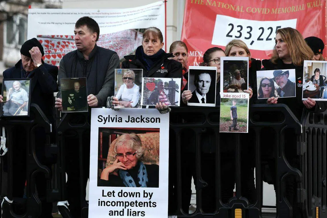 Bereaved family members hold photographs of lost loved ones outside the UK Covid-19 Inquiry in London. They wanted to confront Johnson over claims that he told colleagues he would prefer to see people die in large numbers than order a second lockdown.