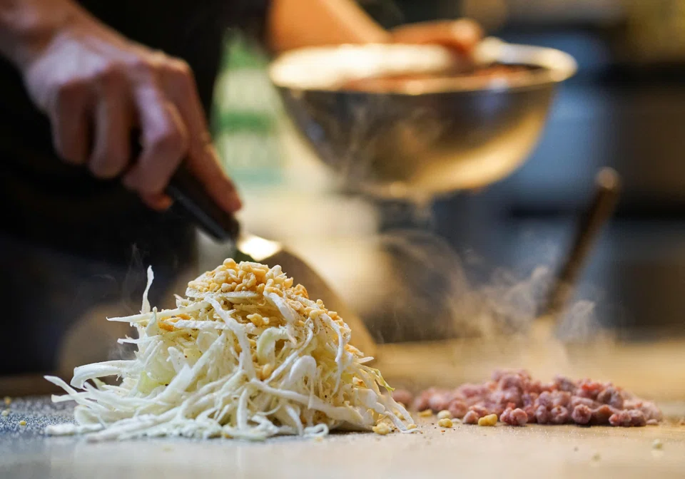 Okonomiyaki is a pancake-shaped mix of noodles, cabbage, egg, meat and seafood, topped with a distinctive sweet-and-sour sauce and fried on a hot metal plate. It is a local speciality in Hiroshima, western Japan.