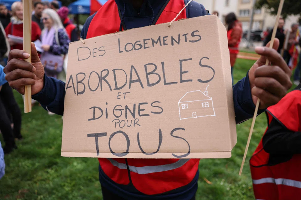 A protestor holds a placard which reads "affordable and decent housing for everyone" at a recent event last month. The sky-high cost of buying or renting a home in Luxembourg has made living there nearly impossible for some.