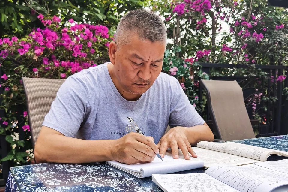 Liang Shi, 56, goes through exam papers ahead of the entrance exam in Chengdu, China's southwestern Sichuan province. The self-made millionaire has taken the exam 26 times but has consistently failed to get the required grades to send him to his chosen university. 