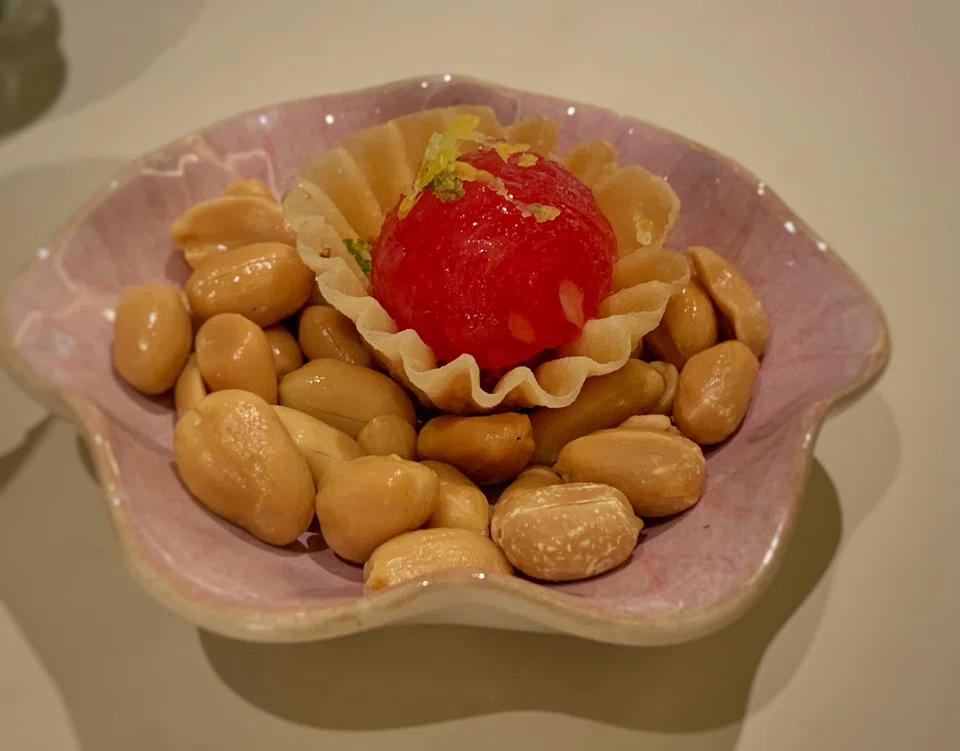 Amuse bouche of watermelon, toasted coconut and smoked fish in a crispy cup.