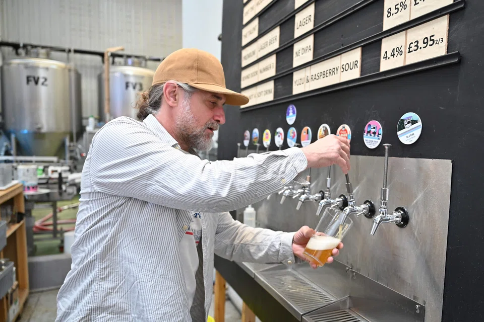 A worker pours a pint of beer at Pressure Drop Brewery, in north London; Pressure Drop is hoping the experiment will not only improve their employees’ productivity but also their well-being. At the same time, it will reduce their carbon footprint.