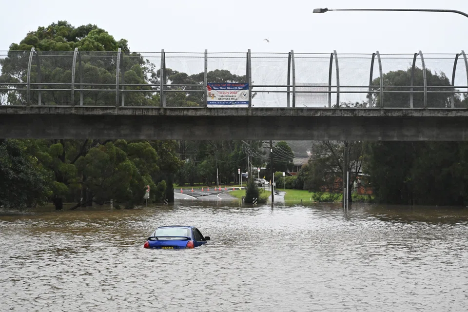 A car abandoned in floodwaters in Lansvale in Western Sydney, Australia, July 3, 2022. Torrential rain and damaging winds hit New South Wales, forcing the evacuation of thousands of residents. 