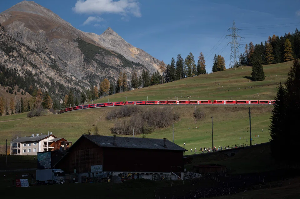 The 1,910-metre (6,266-foot) train, composed of 25 separable multiple-unit trains, or 100 coaches, travelled through the Alps in the eastern Swiss canton of Graubunden.