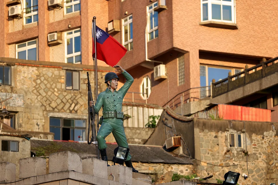 A Taiwan flag flutters behind a soldier statue on Dongyin island of Matsu archipelago in Taiwan, Aug 15, 2022. 