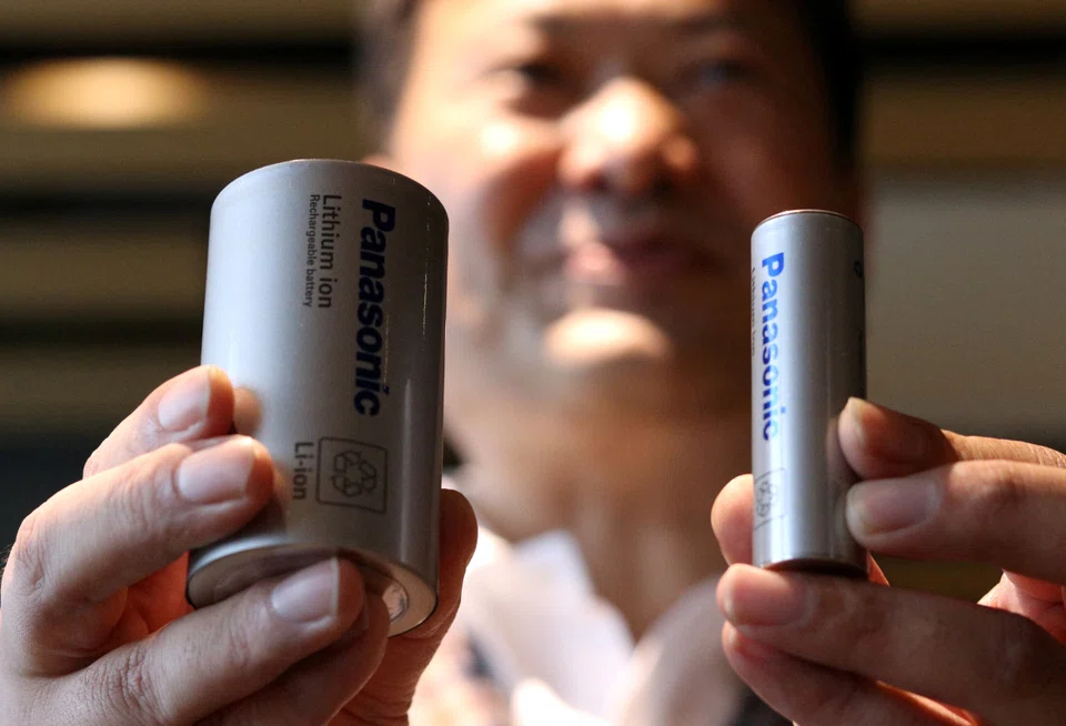 Panasonic Energy CEO Kazuo Tadanobu holds a prototype of the 4680 format battery cell (left) next to the current 2170 battery supplied to Tesla Inc during a news conference in Tokyo, Oct 25, 2021.