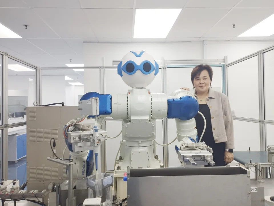 Eunice Ng with Ms Ugene, the company's first robot, which was introduced in 2014. 