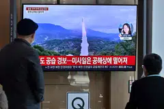 People watch a television screen showing a news broadcast about a North Korean missile test in Seoul, Nov 2, 2022. In October, North Korea test-fired a ballistic missile farther than ever before, sending it soaring over Japan for the first time in five years.