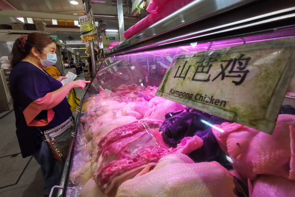 A customer shopping for poultry at a wet market stall in Clementi in June. The price of meat jumped by 10.1 per cent year on year that month.