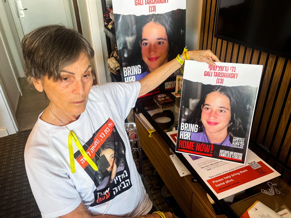  Kamelia Hoter Ishay, 73, grandmother of Gali Tarshansky, 13, who was taken hostage on Oct 7 during the deadly attack by Palestinian Islamist group Hamas, holds up a poster with a picture of Gali.