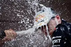 Red Bull's Max Verstappen celebrates with champagne on the podium after winning the Monaco Grand Prix.