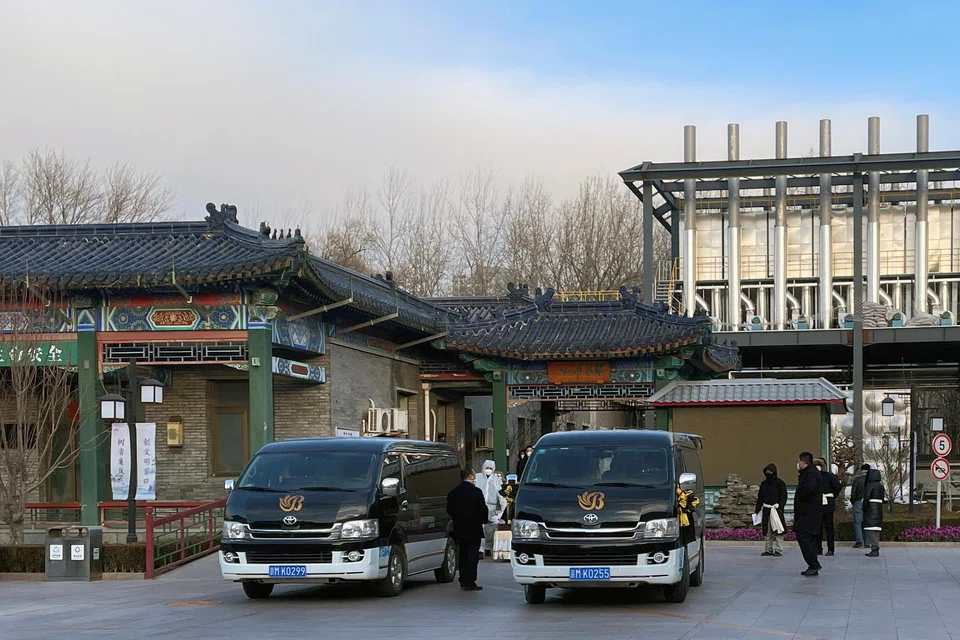 Workers in protective suits move a casket outside a crematorium at a funeral home, amid the coronavirus disease outbreak in Beijing.
