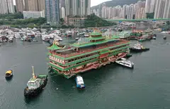 An aerial photo shows Hong Kong's Jumbo Floating Restaurant, an iconic but aging tourist attraction designed like a Chinese imperial palace, being towed out of Aberdeen Harbour on June 14, 2022, after its popularity dimmed in recent years even before the coronavirus hit. PHOTO: AFP
