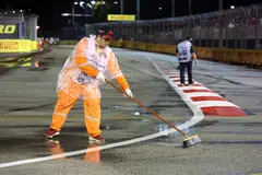 Workers sweep excess rainwater off the Formula 1 track to ensure safe race conditions. Similar efforts are needed to ensure mental health at the workplace.