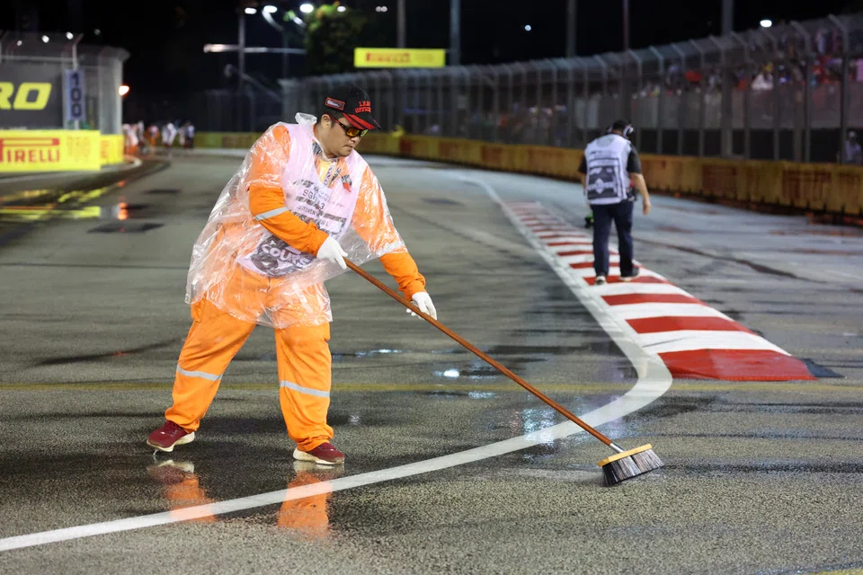 Workers sweep excess rainwater off the Formula 1 track to ensure safe race conditions. Similar efforts are needed to ensure mental health at the workplace.