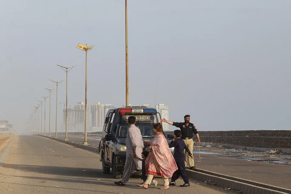 A policeman instructs people to vacate a beach in Karachi before cyclone Biparjoy hits by the end of the week. At least 20,000 people had been evacuated from the storm’s path, while across the border in India’s Gujarat state, authorities said they had also helped a similar number to move.