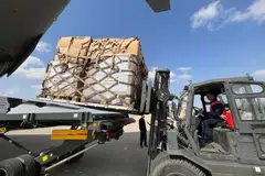 Volunteers from Qatar and Egypt’s Red Crescent humanitarian organisations unload aid destined for the Palestinians of the Gaza Strip at Egypt's el-Arish airport in the north Sinai peninsula on Oct 22, 2023, amid the ongoing battles between Israel and the Palestinian group Hamas. 