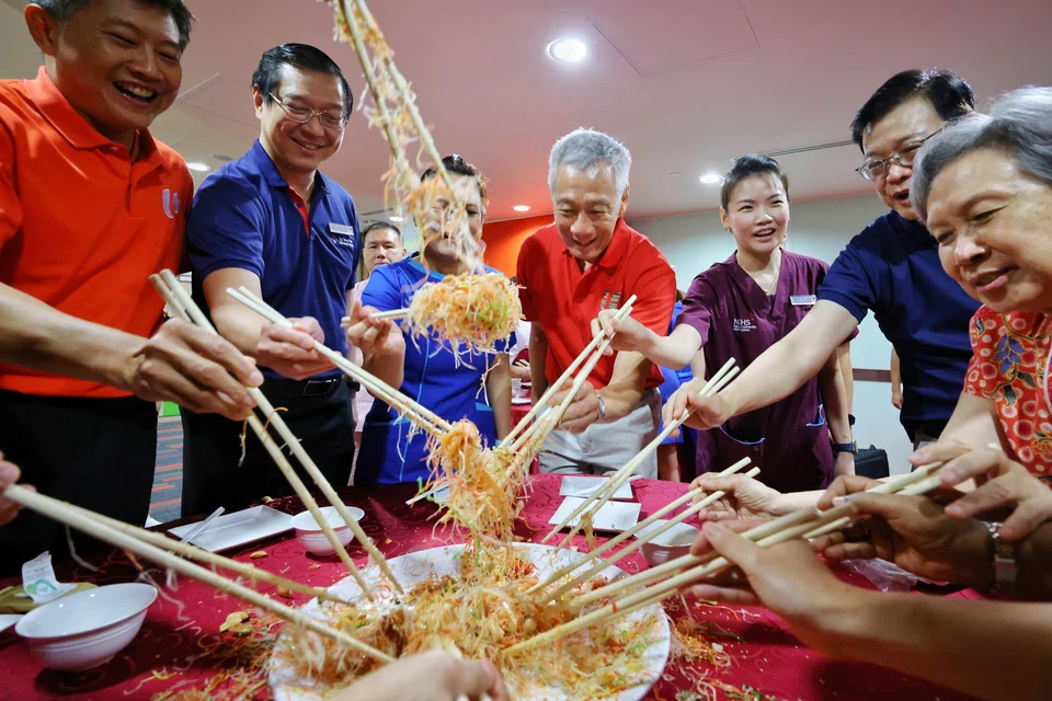 Prime Minister Lee Hsien Loong taking part in a lo hei celebration with (from left) NTUC secretary-general Ng Chee Meng, NTFGH CEO designate Assoc Prof Dan Yock Young, nurse clinician Neo Li Ling, physiotherapist Choo Soo Chian, NTFGH CEO Dr Quek Lit Sin, and Mdm Ho Ching during a visit, on the eve of the Lunar New Year, to Ng Teng Fong General Hospital on Feb 9.