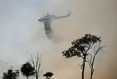 A water-bombing helicopter fights bushfires near the town of Dalveen, Queensland, Australia, Nov 2, 2023.