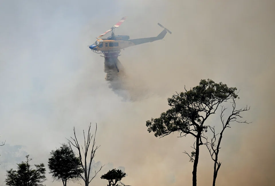 A water-bombing helicopter fights bushfires near the town of Dalveen, Queensland, Australia, Nov 2, 2023.