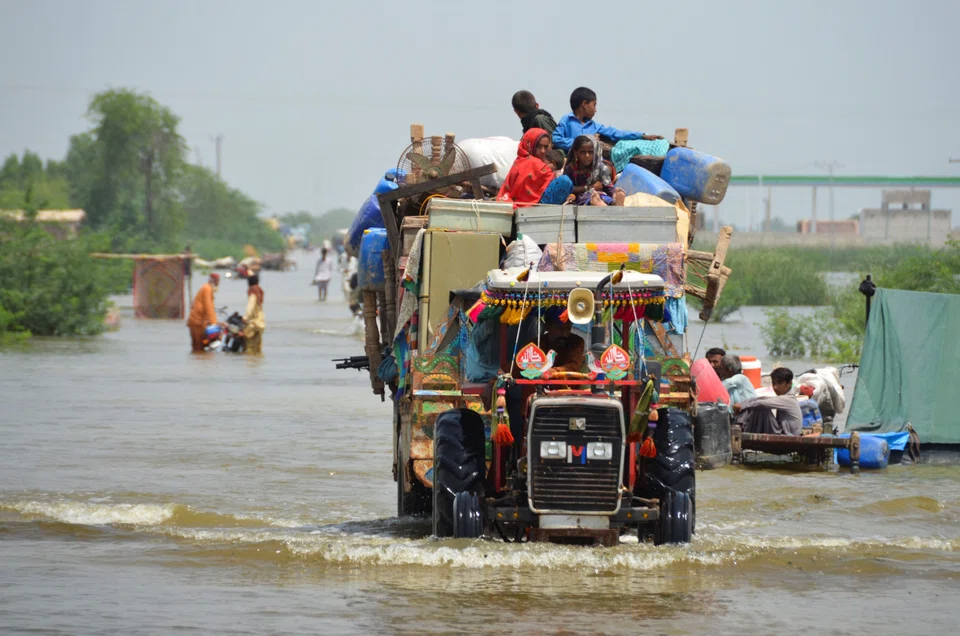 A family evacuating following rains and floods during the monsoon season in Sohbatpur in Pakistan on Aug 29. The floods are expected to have an economic impact of at least US$10 billion, worsening the economic fortunes of a country already beset by political turmoil and raging inflation. 