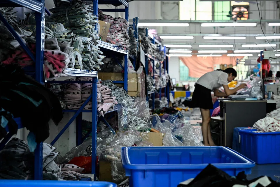 A worker makes clothes at a garment factory that supplies SHEIN, a cross-border fast fashion e-commerce company in Guangzhou.  After a reprieve in June, when Covid restrictions in places like Shanghai and elsewhere were eased, virus cases flared up again in multiple regions, a threat to the economy’s fragile recovery. Factory activity contracted in July. 