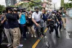 Independent candidate Chadchart Sittipunt (in white shirt) leaves after casting his vote in the governor elections in Bangkok on May 22, 2022. 